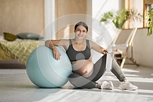 Exercise And Pregnancy. Beautiful Pregnant Woman In Activewear Sitting Near Big Fitball