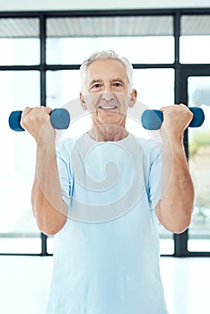 Exercise should always be a priority. a senior man working out with dumbbells.