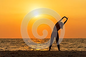 Exercise spirit lifestyle mind woman peace vitality, silhouette outdoors on the Sea sunrise, relax vital abstract. photo