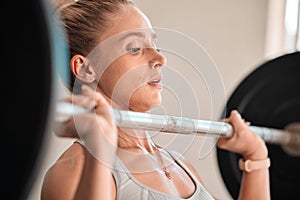 Exercise, weightlifting and a woman bodybuilder in the gym for a workout to build a strong muscular physique. Fitness