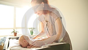 Exercises for babies - baby lying on his stomach and his ginger mother patting him on the back