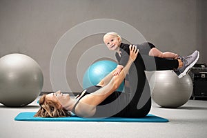 Exercises with the child. Mom trains fitness with a small child.
