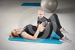 Exercises with the child. Mom trains fitness with a small child.