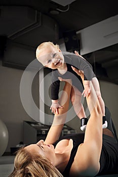 Exercises with the child. Mom trains fitness with a small child.