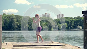 Exercises for the gluteal muscle. Barefoot sports on the lake. 4k video.
