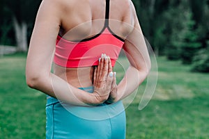 Exercises for proper posture. Body of young woman with her palms folded behind her back in Paschima Namaskarasana asana