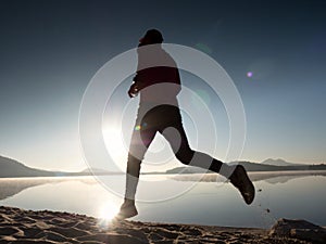 Exercising on the beach at sunset, sun at horizon