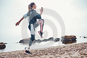 Exercising every morning. Side view of young sporty disabled woman with prosthetic leg is doing sport exercises on the