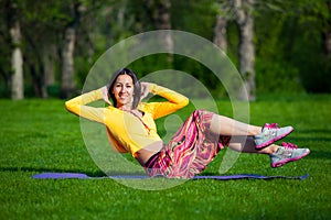 Exercising fitness woman sit ups outside during