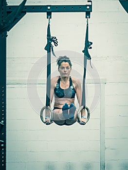 Exercising  woman holding gymnast rings