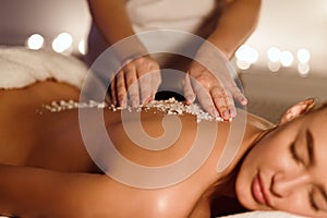 Exfoliation Treatment. Young Woman Enjoying Salt Massage