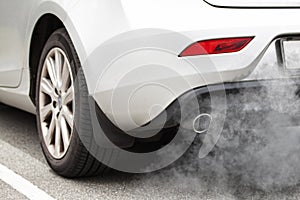 Exhaust pipe of a car - blowing out the pollution from the back of a white car