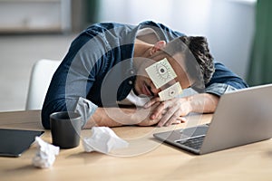 Exhausted arab guy with eyes drawing sleeping at workdesk