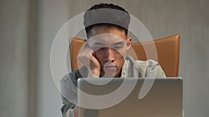 Exhausted Asian employee falls asleep working in laptop