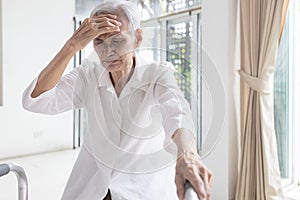 Exhausted asian senior woman is touching her head with hand,symptoms of vertigo illness,loss balance dizzy,meniereâ€™s disease,
