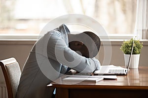 Exhausted biracial man fall asleep working at laptop