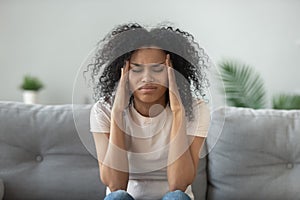 Exhausted black woman massage head suffering from migraine