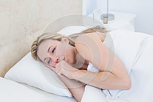 Exhausted blonde woman crying in bed