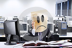 Exhausted businessman with cardboard head