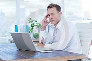 Exhausted businessman drowsing on his laptop