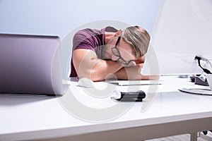 Exhausted Businessman Sleeping On Desk