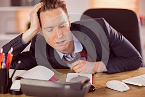 Exhausted businessman sleeping at his desk