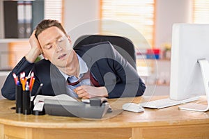 Exhausted businessman sleeping at his desk