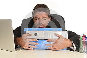Exhausted businessman suffering stress at office computer desk