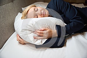 Exhausted businesswoman sleeping peacefully in her bedchamber