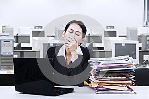 Exhausted businesswoman yawning at office