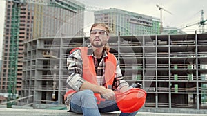 Exhausted construction worker resting during work break on building site