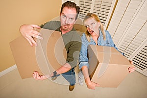 Exhausted Couple Holding Moving Boxes