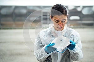 Exhausted crying doctor/nurse in coronavirus protective gear N95 mask.Covid-19 pandemic outbreak.Fatalities grief.Frontline worker