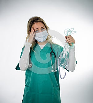 Exhausted Doctor holding medical ventilator after shift in the coronavirus intensive care unit