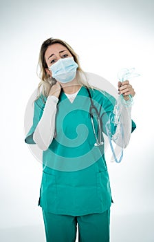 Exhausted Doctor holding medical ventilator after shift in the coronavirus intensive care unit