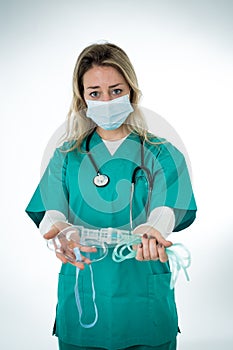 Exhausted Doctor holding medical ventilator after shift in the coronavirus intensive care unit