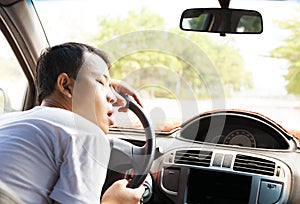 Exhausted driver resting on steering wheel