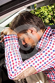 Exhausted driver resting on steering wheel