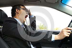 Exhausted driver yawning and driving car