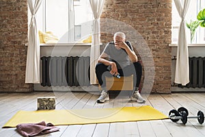 Exhausted elderly man resting after his fitness workout