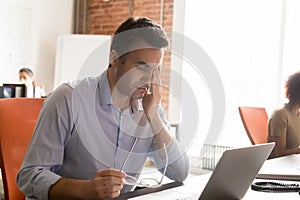 Exhausted employee suffer from dizziness working at laptop