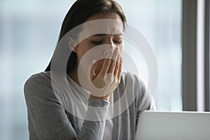 Exhausted female employee sigh feeling fatigue at workplace