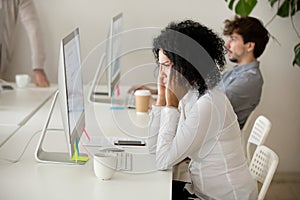 Exhausted female employee suffering from headache touching templ