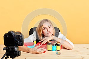 Exhausted female nutritionist grabs bunch of diverse vitamins and supplements