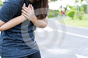 Exhausted female runner suffering painful angina pectoris or asthma breathing problems after training hard on summer. Running over