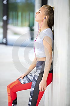 Exhausted Fit Woman In Sportswear Leaning On Wall