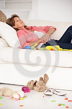 Exhausted grandmother enjoying a rest on sofa