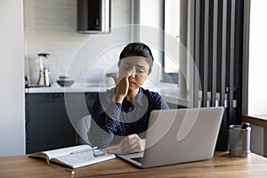 Exhausted Indian woman suffer from dizziness working on laptop