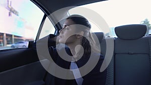 Exhausted lady in formal suit sitting on car backseat, burnout at work, troubles