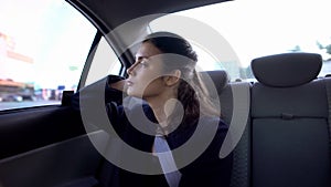 Exhausted lady in formal suit sitting on car backseat, burnout at work, troubles